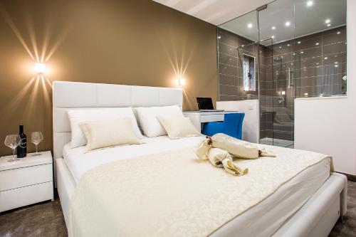 1 dormitorio con 1 cama blanca grande y ducha en Holiday Apartments & Rooms, en Split