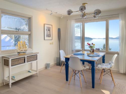 a dining room with a blue table and chairs at Lucky Stone Retreat - private beach & Acadia view in Sullivan