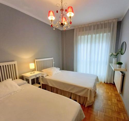 ein Hotelzimmer mit 2 Betten und einem Kronleuchter in der Unterkunft APARTAMENTO ALFICA VUT-981-AS in Llanes