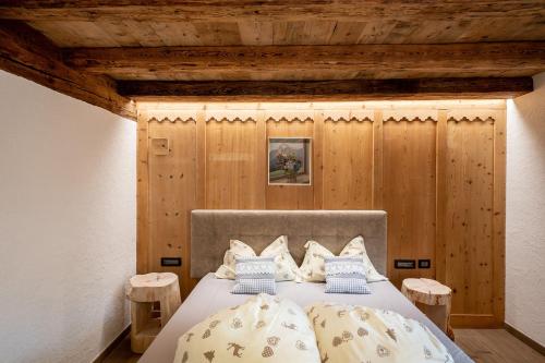 a bedroom with a large bed with wooden walls at Chalet Catinaccio Rosengarten 56 in Pozza di Fassa