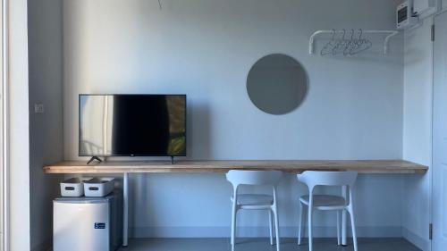 a table with a tv on a blue wall at baan thammada in Nan