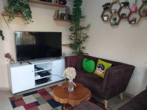 sala de estar con sofá y TV en La Casa Del Pinito en Sonsonate
