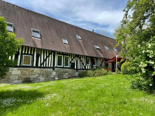 a building with a grass yard in front of it at Le Vieux Pressoir in Pont-lʼÉvêque