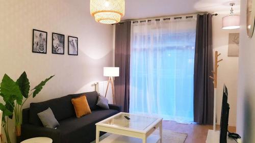 un salon avec un canapé et une table dans l'établissement II APPART 2 PIÈCES, NEUF RER D à 200m PARKING NETFLIX Evry Courcouronnes, Évry-Courcouronnes