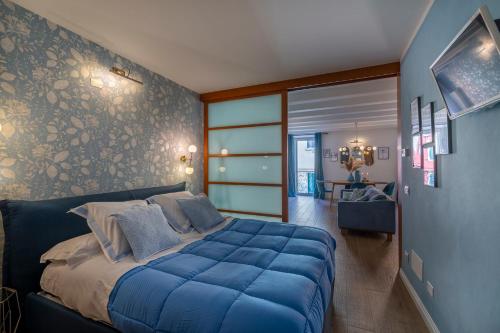 una camera da letto con un grande letto con lenzuola blu di The Cozy Loft, un angolo alla moda nel cuore di Verona a Verona