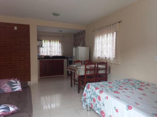 Schlafzimmer mit einem Bett, einem Tisch und Stühlen in der Unterkunft Recanto Três Irmãs in Companhia