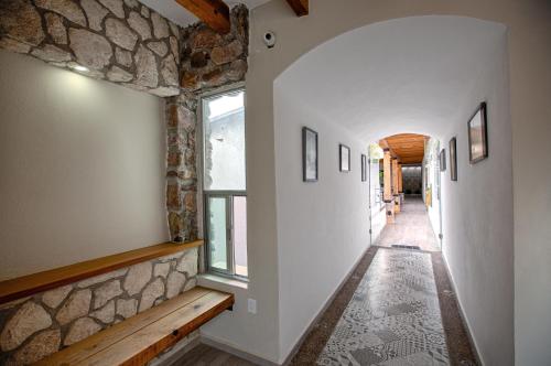 a hallway with a stone wall and a window at Hotel la Cuesta Toscana in Bernal