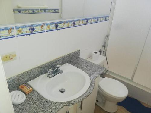 a bathroom with a sink and a toilet and a mirror at Punta Barandua Beach Department in Santa Elena