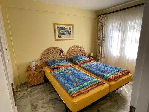- une chambre avec 2 lits et une fenêtre dans l'établissement El Lobo de Mar Estepona, à Estepona