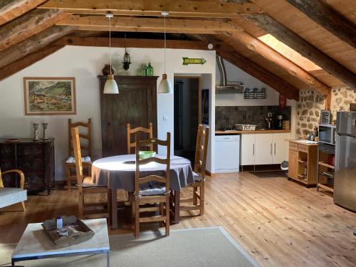 une cuisine et une salle à manger avec une table et des chaises dans l'établissement La Bonbonnière, au Chambon-sur-Lignon