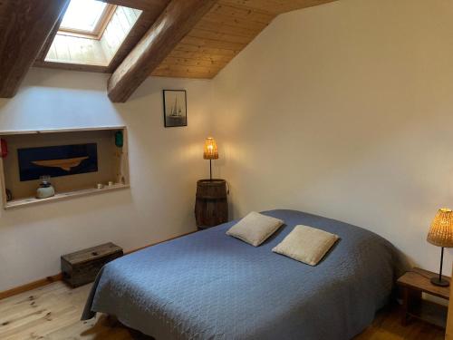 a bedroom with a blue bed with two pillows on it at La Bonbonnière in Le Chambon-sur-Lignon