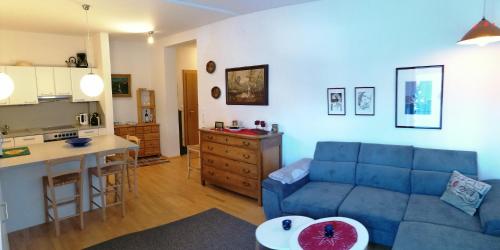 a living room with a blue couch and a kitchen at Enzian Top 2 - O SOLE MIO in Bad Kleinkirchheim
