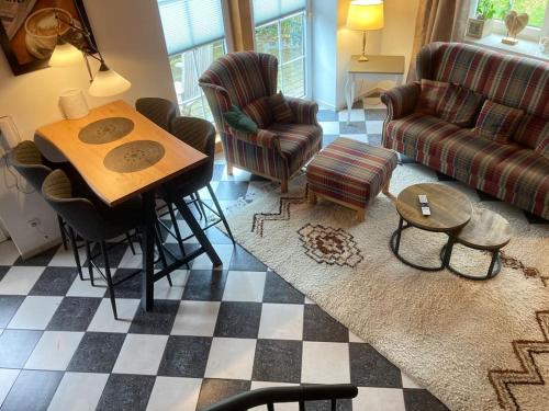 a living room with a table and chairs at Gemütliches Landhaus in ruhiger Lage. in Moringen