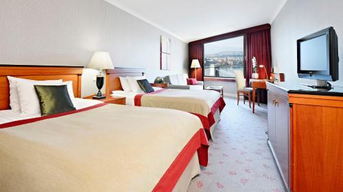 a hotel room with two beds and a flat screen tv at InterContinental Budapest by IHG in Budapest