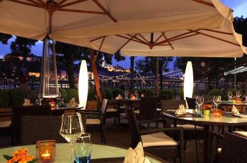 a restaurant with tables and umbrellas at night at InterContinental Budapest by IHG in Budapest
