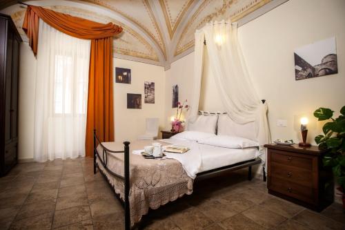 a bedroom with a bed with an ornate ceiling at Camere Del Re in Tarquinia