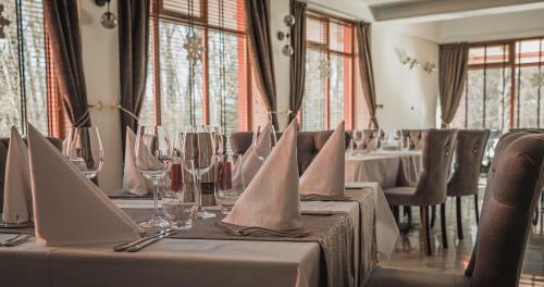 ein Esszimmer mit Tischen und Stühlen mit Gläsern und Servietten in der Unterkunft Хотелски комплекс Белият кон in Targowischte