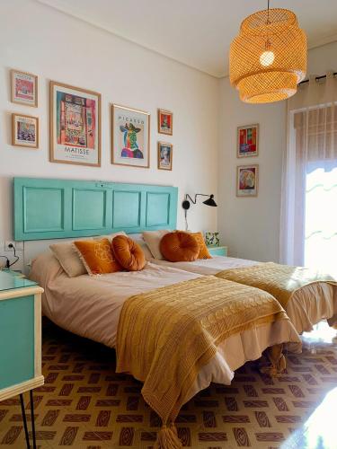 a bedroom with a large bed with orange pillows at Alojamiento estilo Boho con mucho encanto in Ponferrada