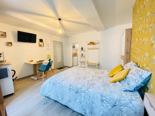 - une chambre avec un lit bleu et un bureau dans l'établissement appartement chic, à Laon