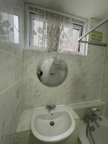 Baño blanco con lavabo y espejo en 41 Tanners Endlane, en Edmonton