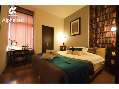 a bedroom with a bed and a desk and bookshelves at Alphabed Takamatsu Hyogomachi - Vacation STAY 11903 in Takamatsu