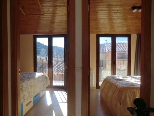 two beds in a room with doors to a balcony at Flor de Lis in Benasal