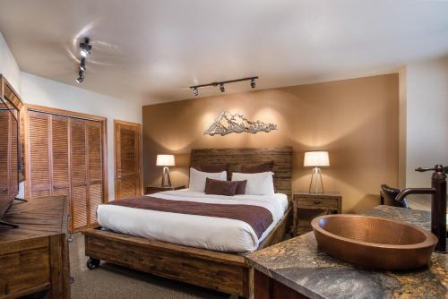 een slaapkamer met een groot bed en een bad bij Stunning Zephyr Mountain Lodge Condo Overlooking The Village Plaza condo in Winter Park