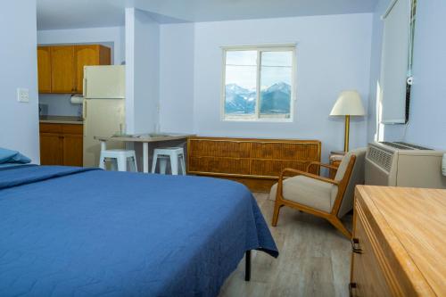 1 dormitorio con cama, mesa y cocina en Dark Sky Suites en Westcliffe