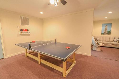 a ping pong table in the middle of a room at Salty Paradise home in Holden Beach