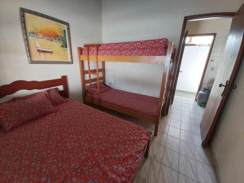 een slaapkamer met een bed en een stapelbed bij 0006.03 - Maranduba - Chalé - 1 Dorm - 5 Pess - 3 Quadras Do Mar - Piscina Coletiva - WIFI in Ubatuba