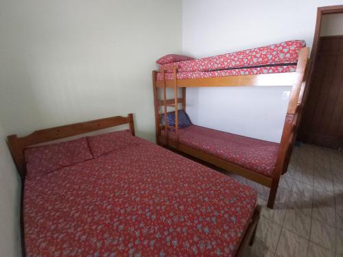 een slaapkamer met een bed en een stapelbed en een stoel bij 0006.02 - Maranduba - Chalé - 1 Dorm - 5 Pess - 3 Quadras Do Mar - Piscina Coletiva - WIFI in Ubatuba