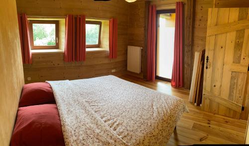 1 dormitorio con 1 cama y 2 ventanas en Gîte ardennais Rogery - Yá-át-ééh Naşbaş en Gouvy