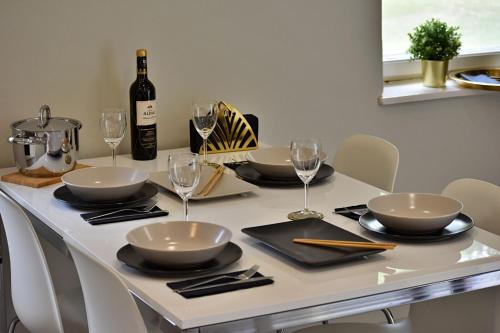 a table with glasses and a bottle of wine at Hello Balcsi Apartmanház in Tihany