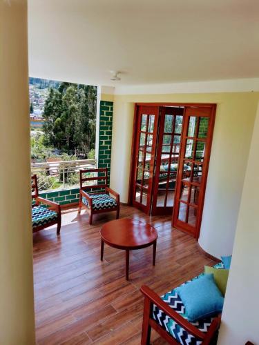 a living room with chairs and a table and a window at Fundo San Silvestre in Huaraz