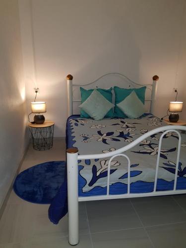 a bedroom with a bed with a blue and white comforter at LA PERLE MARINE in Le Prêcheur