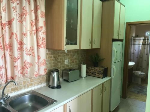 a kitchen counter with a sink and a refrigerator at GALINI STEGNA BEACH in Archangelos