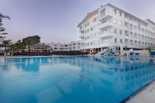 a large swimming pool in front of a hotel at Kilikya Hotel in Kizkalesi