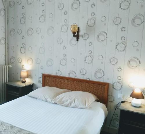 ein Schlafzimmer mit einem Bett mit zwei Tischen und zwei Lampen in der Unterkunft Le Soleil D'or in Vimoutiers