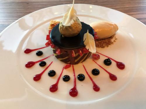 a white plate topped with a dessert with red sauce at Crowne Plaza Reading in Reading