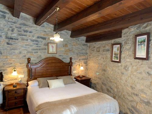 a bedroom with a bed and a stone wall at Casa Rural Torre Gargallo in Morella