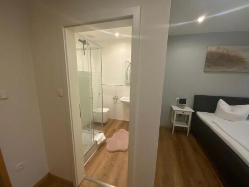 a bathroom with a shower and a bed and a toilet at Berghotel Sülbeck in Nienstädt