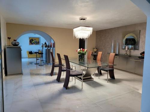 a dining room with a glass table and chairs at casaenjoysamana in Los Naranjos