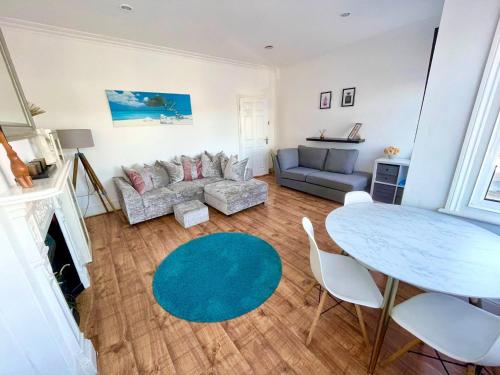 a living room with a table and a couch at Large 3 Bedroom modern apartment close to central London in Finchley