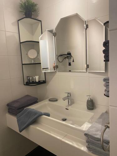 a white bathroom with a sink and a mirror at Das Fex in Aschau