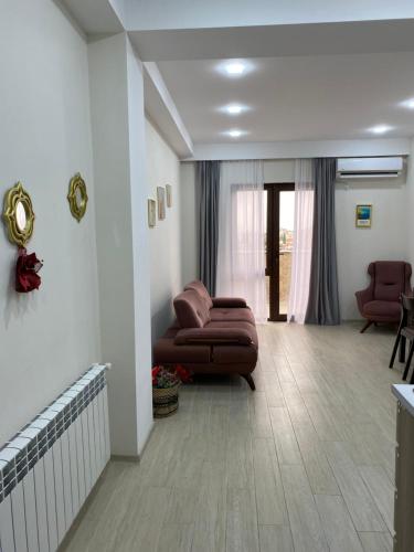 a living room with a brown couch in a room at Valkhida's Apartment in Kutaisi