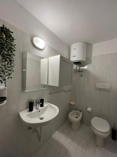 uma casa de banho branca com um lavatório e um WC em CASA ELISA em Cavo