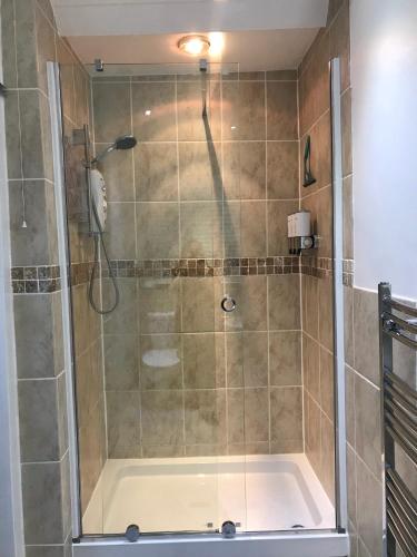 a shower with a glass door in a bathroom at Wisteria house in Plymouth