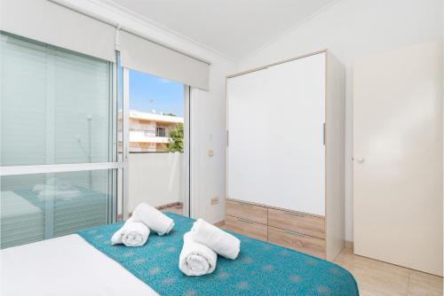 a bedroom with a bed and a large window at Casa Hawaii in Port d'Alcudia