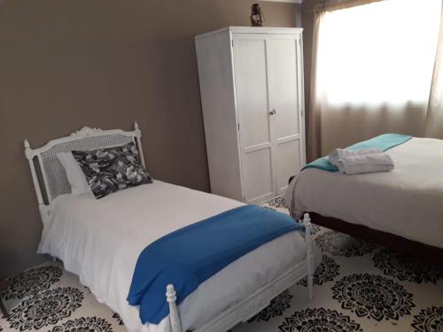 1 dormitorio con 2 camas y vestidor blanco en Donde brilla el sol en Dina Huapi