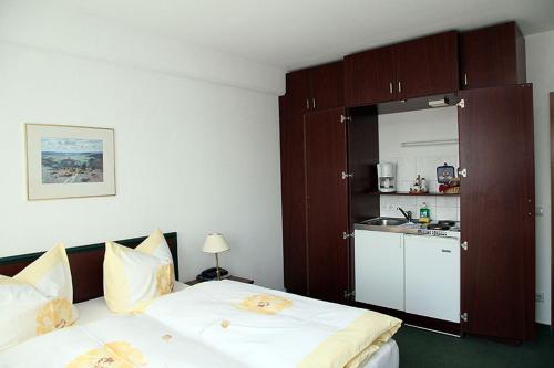 1 dormitorio con 1 cama y cocina pequeña en Pension am Markt, en Lübben